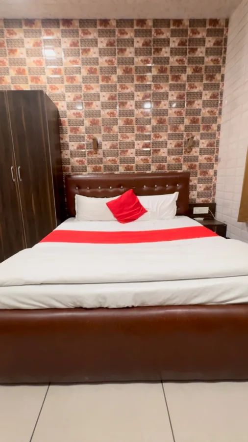 Hotel Max room with a double bed, red bedding accents and a patterned feature wall