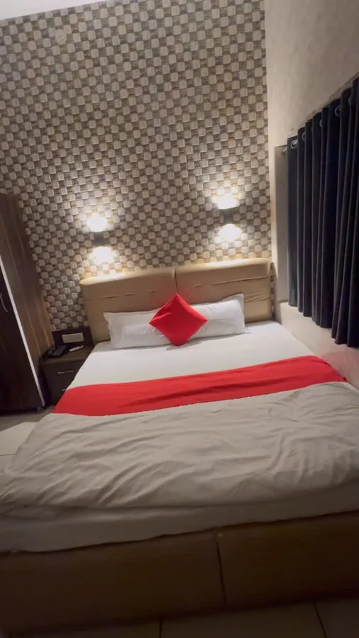 Hotel Max bed with red cushions and a checkered feature wall