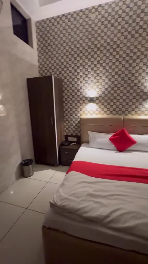 Hotel Max bedroom with red cushions and a checkered feature wall