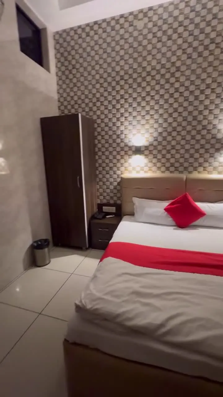 Hotel Max bedroom with red cushions and a checkered feature wall
