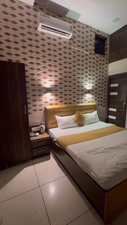 Another view of a Hotel Max bed with gold accents below a padded headboard