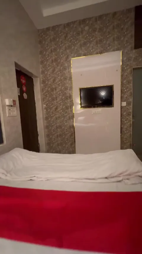 Hotel Max bedroom facing the wall-mounted television and entrance